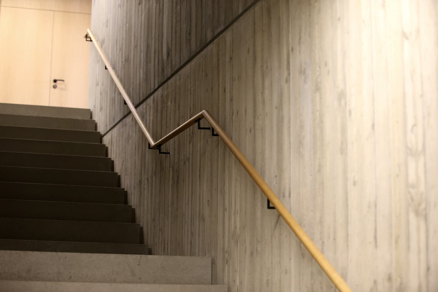 Betontreppe mit maßgefertigten Holzhandläufen im Bürgerzentrum Möttingen
